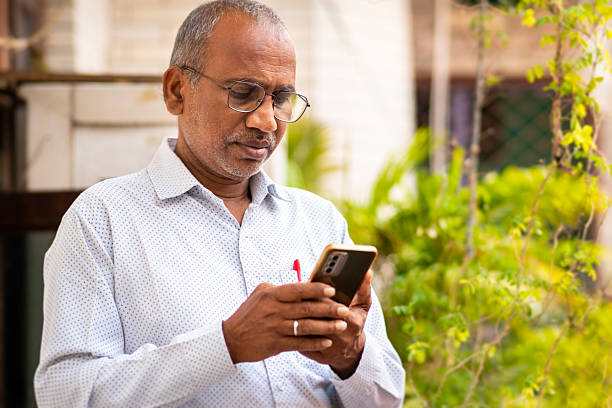 istock Portrait of middle aged man in eyeglasses using a smartphone in balcony. 2212060683