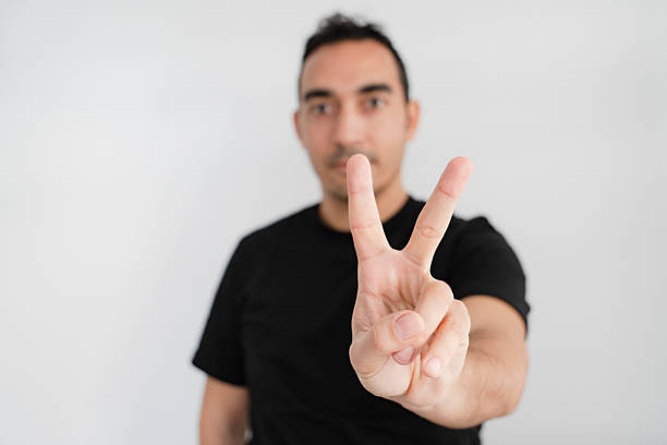 Peace hand gesture sign, two finger hand, man wearing tshirt