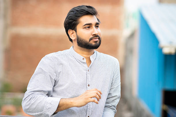 istock Portrait of a serene handsome indian young man looking way and thinking with a blank expression. 2212064076