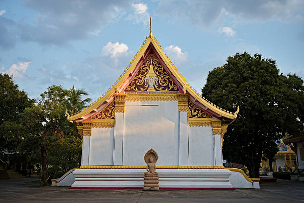 In the heart of Savannakhet, Wat Yai Xayaphoum reveals the richness of Laos' Buddhist architecture. Under the golden light of late afternoon, its red and gold roofs sparkle, contrasting magnificently with the pastel blue sky. The delicate carvings and motifs adorning the facades are a testament to remarkably fine craftsmanship, where every detail seems imbued with spirituality.The calm that reigns on the esplanade accentuates the majesty of the place. A few trees provide shade and create an atmosphere conducive to meditation. Away from the hustle and bustle of modern life, this temple is a true haven of peace where time seems to stand still.A symbol of Laos' religious fervor and cultural identity, Wat Yai Xayaphoum invites contemplation, respect, and wonder. Its timeless beauty captures the soul of the country and offers a moment of grace to visitors seeking authenticity.