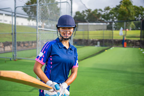 istock Female Junior Cricket Player Smiling with Bat at Practice Nets 2212068358