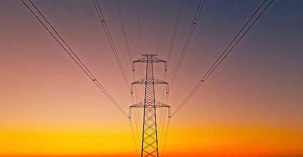 istock Electrical Transmission Tower Silhouette Against Dramatic Orange And Purple Sunset Sky 2212068993