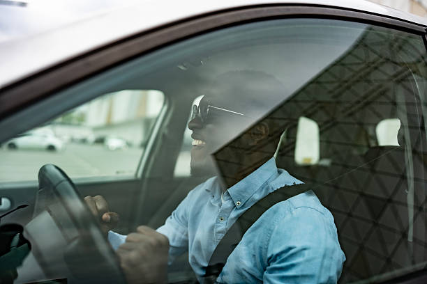 istock Happy Man Driving a Car With Bright Expression Through Urban Snapshot 2212069879