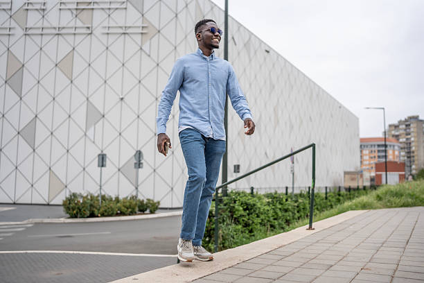 istock Confident Man Walking Outdoors Near Modern Architecture 2212069957