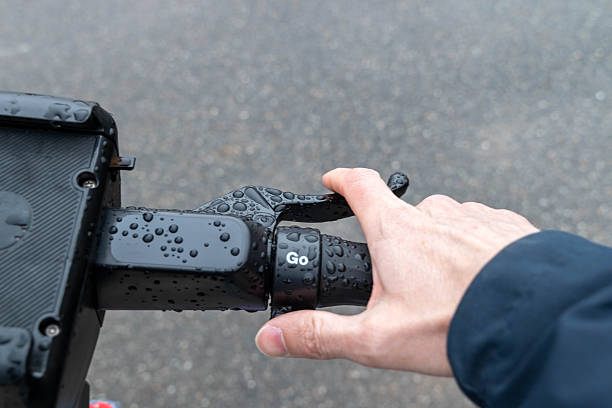 istock Hand accelerating electric scooter in the rain 2212070850