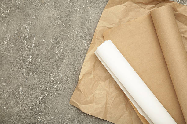 istock Rolls of white and brown baking paper on grey concrete background 2212071334