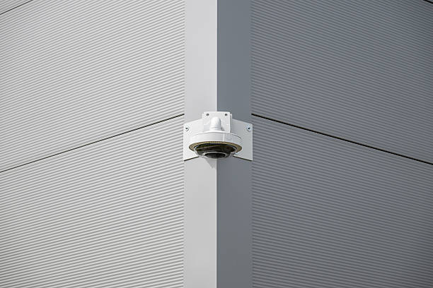 istock Security camera mounted on a building corner monitoring surroundings during daylight hours 2212074150