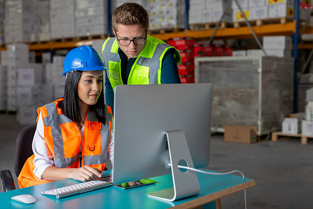 istock Young Male and Female Warehouse Workers Collaborating on a Computer in a Warehouse 2212081744