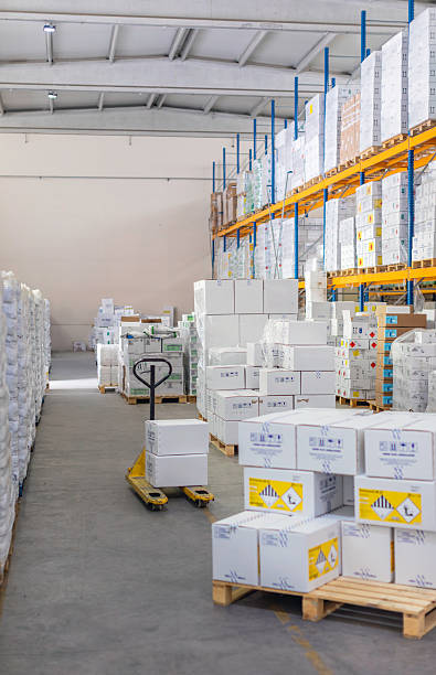 istock Empty Warehouse Aisle with Stacked Boxes and Pallet Jack for Transportation 2212081764