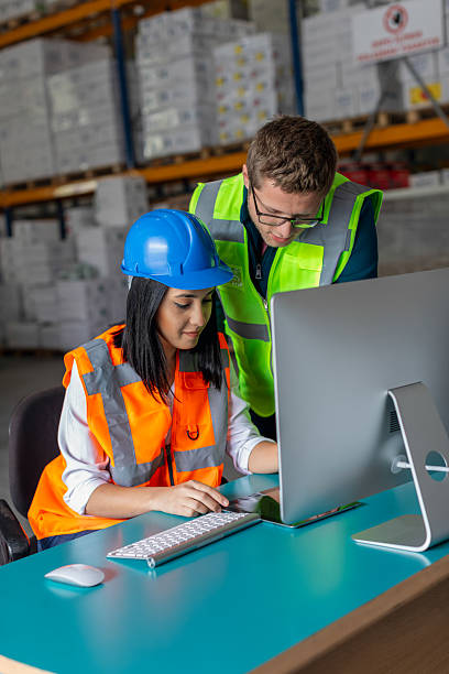 istock Young Male and Female Warehouse Workers Collaborating on a Computer in a Warehouse 2212081766