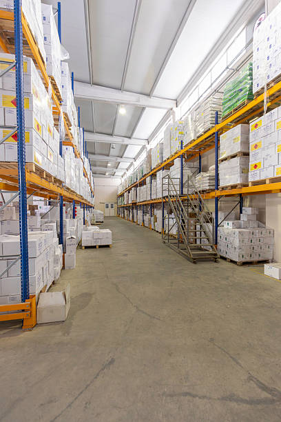 istock Empty Warehouse Aisle with Shelves Stacked with Boxes and Staircase for Access 2212081813