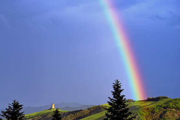 istock view of hilly landscape and rainbow in dark sky 2212089210