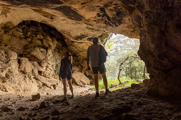 istock Young couple explore cave entrance 2212094046