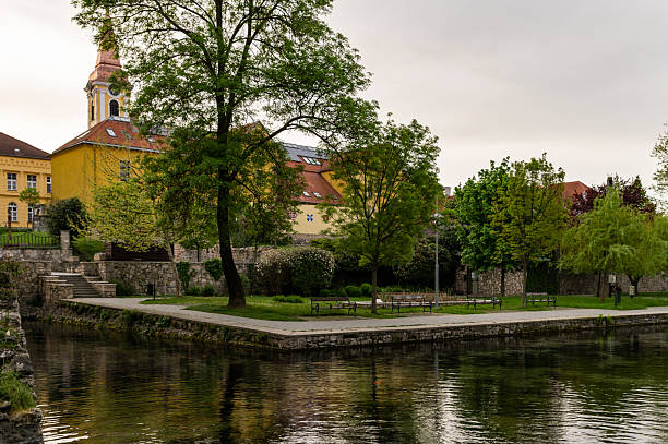 istock Public park with spring trees and a historic church in Tapolca 2212094494