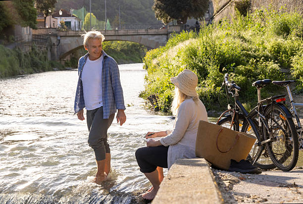 istock Mature couple relax on riverbank in springtime 2212094924