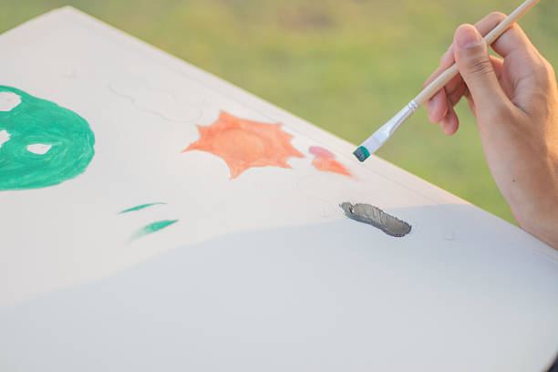 istock A woman sits and draws outdoors in a park as the sun sets. 2212095562