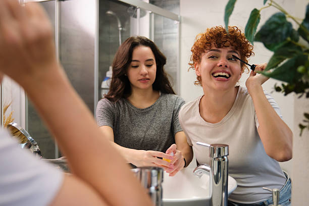 istock Young Women Applying Makeup and Washing Hands in Bathroom Sink 2212103997
