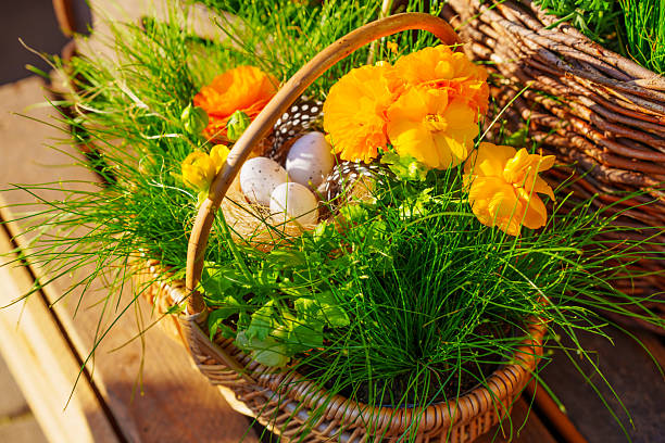 Vibrant Easter basket filled with colorful flowers, decorative eggs, and fresh grass, captured in warm afternoon light on a rustic wooden table.