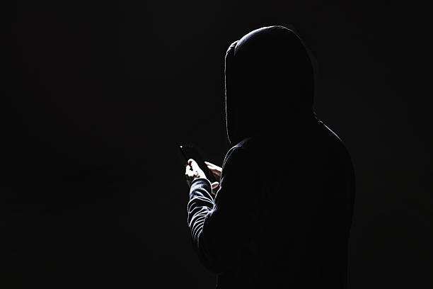 istock Silhouette of man with mobile phone on black background 2212109672