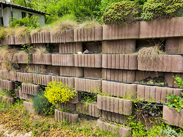The photo shows a flower bed built of concrete bricks, arranged in eight tiers, with yellow and green flowers