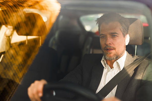istock Businessman driving car and looking away while commuting to work 2212123429