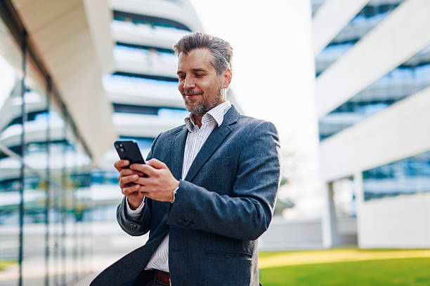 istock Businessman using smartphone outside office building 2212123489