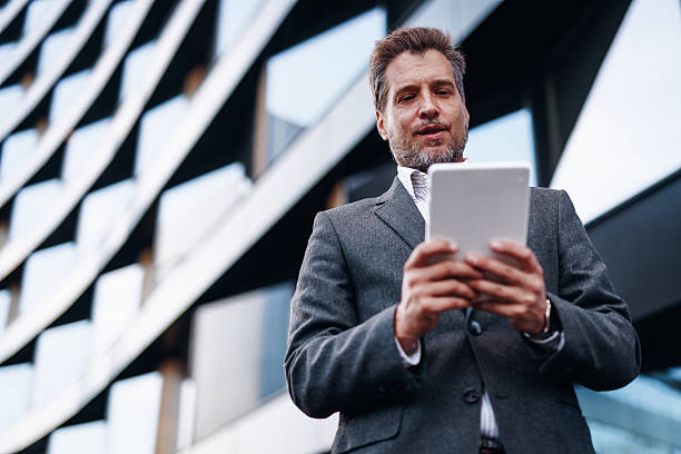 istock Businessman using digital tablet in front of modern office building 2212123593