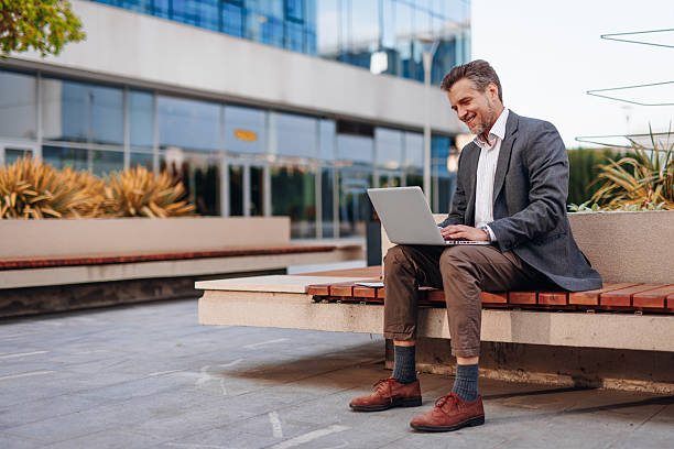 istock Businessman working with laptop outside office building 2212123620