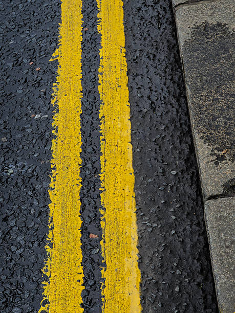 istock A yellow line is painted on a black road 2212126756