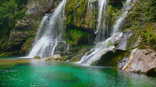 istock Majestic Freshwater Waterfall Cascading Over Mossy Rocks Into Crystal Clear Emerald Pool. Virje Wterfal 2212129554