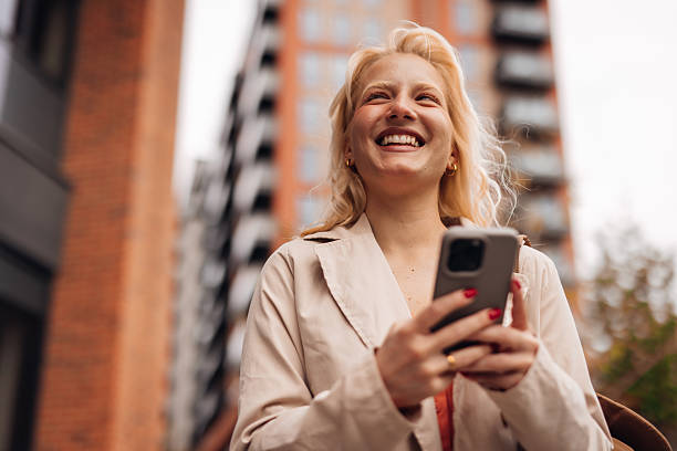 istock Young businesswoman smiling while using mobile phone in the city 2212134900