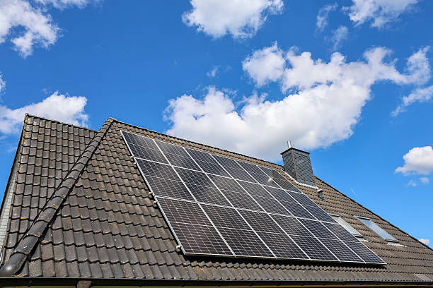 istock Photovoltaic panels producing renewable energy on rooftop under cloudy sky 2212143393