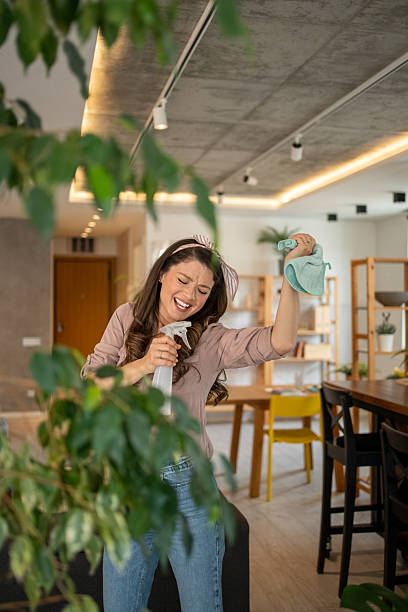 istock Happy housewife singing while cleaning home plants 2212145196