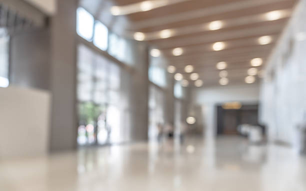 istock Blurred office building lobby or hotel blur background interior view toward reception hall, modern luxury lounge, white room space with blurry corridor and building glass wall 2212153016