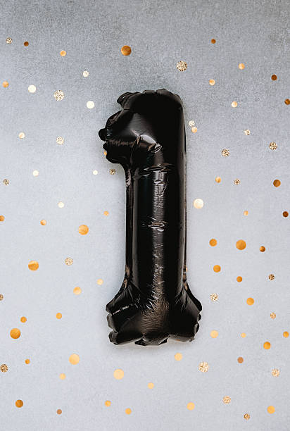 Black one-shaped balloon on a festive background with golden dots