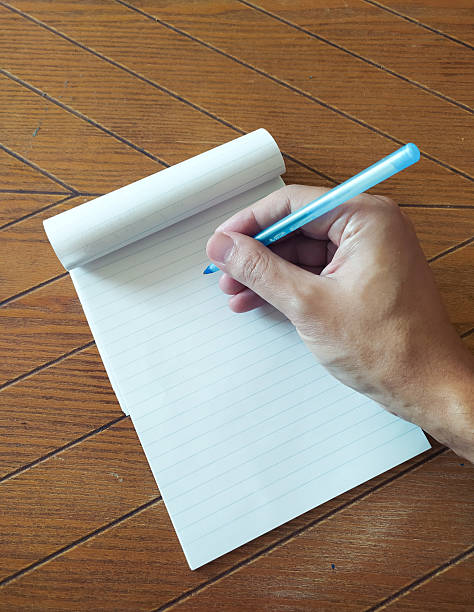 istock A person writes on lined paper with a blue pen. Concept for writing, planning, journaling, or education. Versatile for articles, blogs, websites, and creative projects. 2212153761