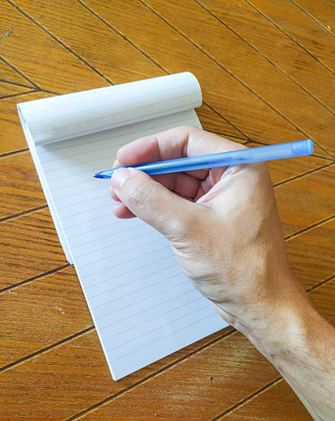 istock Capturing thoughts. Hand writing notes on a lined notepad with a blue pen. Perfect for business, education, planning, reminders, and creative projects. 2212160142