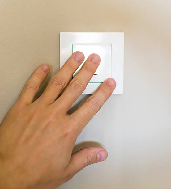 istock Hand pressing a light switch. Concept of energy, home, and automation. Symbolizes control, start, or stop. Suitable for articles on smart homes or efficiency. 2212160145