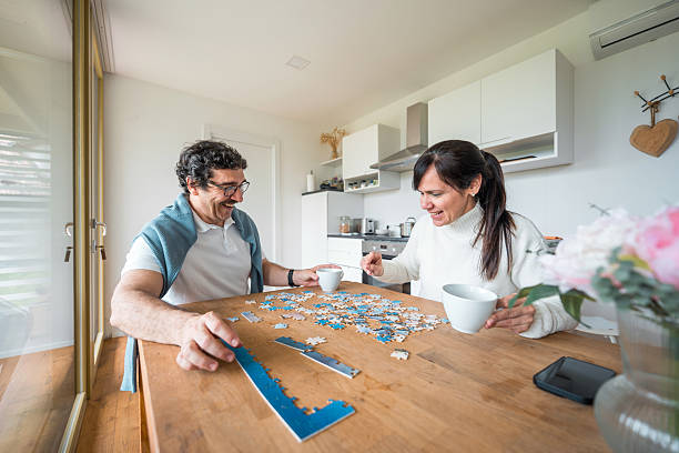 istock Hispanic Couple Solving Jigsaw Puzzle Together In Modern Mobile Home Living Space 2212167985