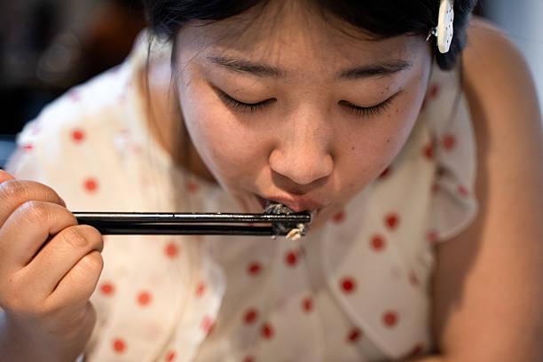 istock An Asian girl who is having a meal 2212168003