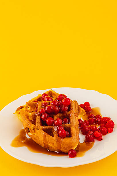 istock Delicious waffle topped with cherries and syrup on a plate 2212176830