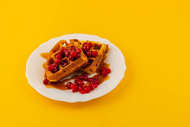 istock Delicious waffles topped with fresh berries and syrup 2212177037