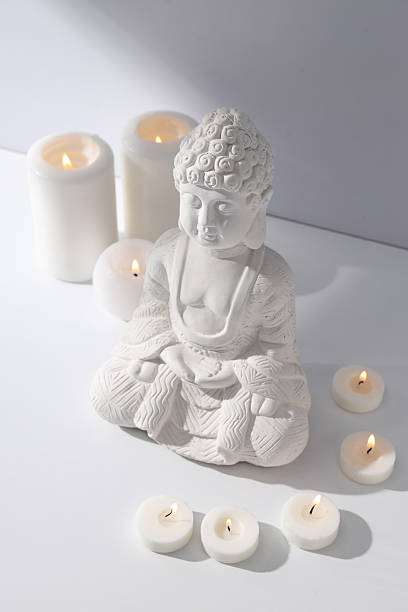 istock Buddha statue and candles on white background 2212177258