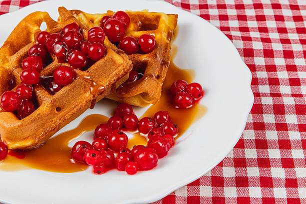 istock Delicious waffles topped with fresh berries and syrup 2212178197
