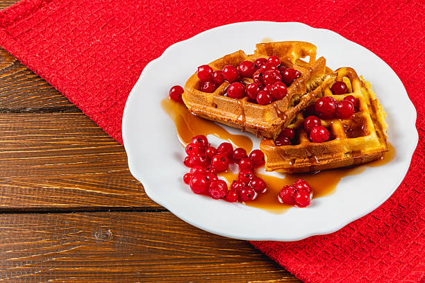 istock Waffles topped with red berries on a white plate 2212179303