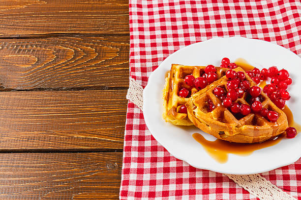 istock Waffles with berries and syrup on checked cloth 2212179380