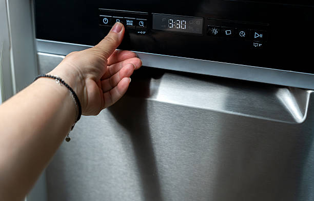 istock Woman's hand presses the program selection button on the dark panel of a dishwasher. Built-in appliances in the kitchen. 2212180901