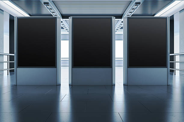 istock Three blank vertical advertising display mockups in modern office hallway with metallic ceiling and tiled floor, ready for presentation layout. 3D Rendering 2212182836