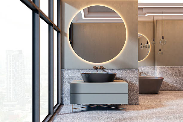 Modern luxury bathroom interior with round backlit mirror, city view window, elegant bathtub, and minimalist vanity furniture in chic ambiance. 3D Rendering