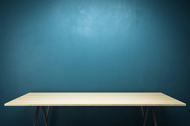 istock Minimalistic wooden desk with clean empty space against dark blue wall background under spotlight, perfect for product presentation or branding mockup. 3D Rendering 2212183182